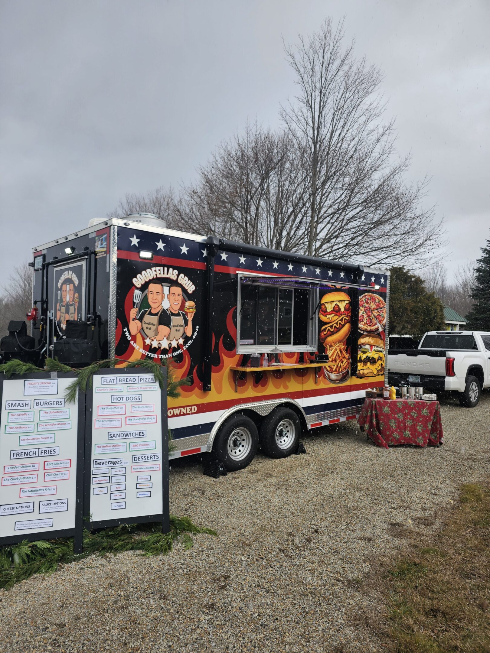 Food truck with fiery theme serving barbecue dishes outdoors.