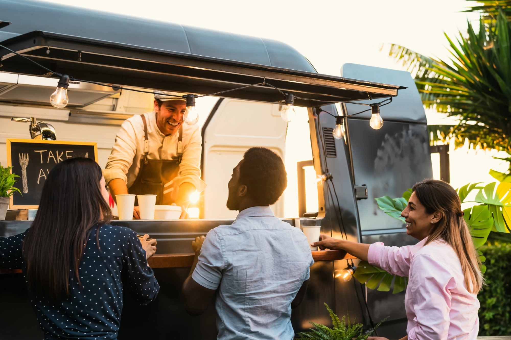 Food truck serving happy customers outdoors.