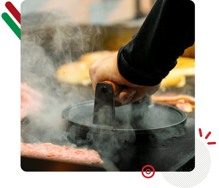 A person cooking with steam rising from a pot on a stove.