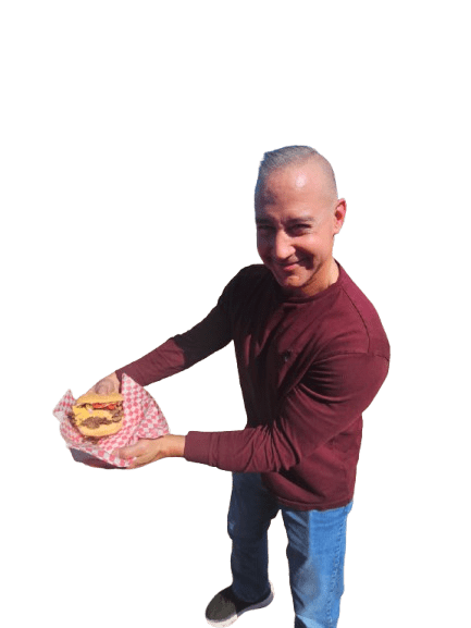 A man smiling while holding a dessert in his hands.